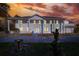 Stately two-story home with white siding, columns, and a manicured front lawn at sunset at 2653 State Road 557, Lake Alfred, FL 33850