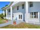 Welcoming front entrance with classic columns, double doors, and inviting porch decor with potted plants at 2653 State Road 557, Lake Alfred, FL 33850
