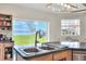 Bright kitchen featuring a double sink with scenic lake view and wooden cabinetry with ample storage at 2653 State Road 557, Lake Alfred, FL 33850