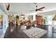 Spacious living room with dark wood floors, large windows, and a ceiling fan provides a bright atmosphere at 2653 State Road 557, Lake Alfred, FL 33850