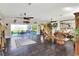 Open living room with hardwood floors, ceiling fans, wicker furniture, and sliding glass doors leading outside at 2653 State Road 557, Lake Alfred, FL 33850