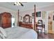 Spacious main bedroom with stylish decor, including dark hardwood floors and a four-poster bed at 2653 State Road 557, Lake Alfred, FL 33850