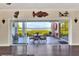 Living room view through sliding doors to outdoor dining area and waterfront scenery in the background at 2653 State Road 557, Lake Alfred, FL 33850