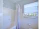 Well-lit bathroom features a bathtub with shower, tiled walls, and neutral accents at 2816 Fairmount Ave, Lakeland, FL 33803