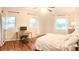 Bright bedroom featuring wood floors, ceiling fan, large windows and a charming work desk at 2816 Fairmount Ave, Lakeland, FL 33803