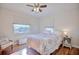 Bright bedroom features a ceiling fan, hardwood floors, and two windows at 2816 Fairmount Ave, Lakeland, FL 33803