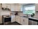 Updated kitchen featuring white cabinetry, stainless steel appliances, tile backsplash, and granite countertops at 2816 Fairmount Ave, Lakeland, FL 33803