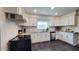 Updated kitchen featuring white cabinets, stainless steel appliances, granite countertops, tile backsplash, and a cooktop oven at 2816 Fairmount Ave, Lakeland, FL 33803