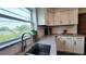 Modern Kitchen featuring a stainless steel sink, white cabinetry, tile backsplash, granite countertops, and a window view at 2816 Fairmount Ave, Lakeland, FL 33803