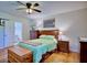 Cozy main bedroom features a ceiling fan, hardwood floors, a decorative chest, and an ensuite bath at 2816 Fairmount Ave, Lakeland, FL 33803
