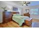 Relaxing main bedroom features hardwood floors, a ceiling fan, stylish furniture, and sun-filled windows at 2816 Fairmount Ave, Lakeland, FL 33803