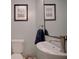 Modern powder room has a unique vessel sink, sleek faucet, framed artwork, and ample lighting at 2816 Fairmount Ave, Lakeland, FL 33803