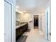 Bathroom with double sink vanity with dark wood cabinets, granite counters, tile floors and walk-in closet at 2929 Flying Blackbird Rd, Bartow, FL 33830