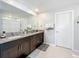Bathroom with double sink vanity with dark wood cabinets, granite counters, tile floors and large mirror at 2929 Flying Blackbird Rd, Bartow, FL 33830