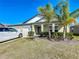 Charming home, featuring a triple garage, and tropical landscaping at the front entrance at 2929 Flying Blackbird Rd, Bartow, FL 33830