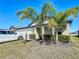 Charming home, featuring a triple garage, and tropical landscaping with mature palm trees at 2929 Flying Blackbird Rd, Bartow, FL 33830