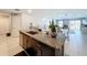 Open-concept kitchen with island, granite countertops, dark cabinets, and stainless steel appliances at 2929 Flying Blackbird Rd, Bartow, FL 33830