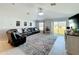 Bright living room featuring a large leather sectional, tile flooring, and sliding glass door to the backyard at 2929 Flying Blackbird Rd, Bartow, FL 33830