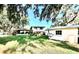 Expansive backyard with lush green lawn and a charming home shaded by mature trees at 302 Luna Rd, Auburndale, FL 33823