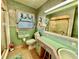 Charming bathroom featuring a pink and green color scheme, tiled walls, and a retro design at 302 Luna Rd, Auburndale, FL 33823