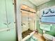 Bathroom featuring a glass-enclosed shower with decorative stones, a built-in cabinet, and retro color scheme at 302 Luna Rd, Auburndale, FL 33823