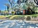 Charming two-story home with a brick facade, green shutters, and well-maintained landscaping at 302 Luna Rd, Auburndale, FL 33823
