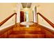 Upstairs hallway with wood railing and floor showing access to a bathroom and bedrooms at 302 Luna Rd, Auburndale, FL 33823
