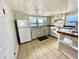 Compact kitchen with white cabinetry, appliances, and neutral countertops at 302 Luna Rd, Auburndale, FL 33823