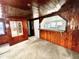 Cozy living room features wood paneling, carpet, and an open view to the kitchen at 302 Luna Rd, Auburndale, FL 33823