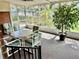 Enclosed patio features a table and chairs, large houseplant, and view of the lush backyard at 302 Luna Rd, Auburndale, FL 33823