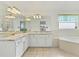 Bathroom features a dual sink vanity, large mirror and separate soaking tub and shower at 307 Balmoral Ct, Davenport, FL 33896