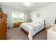 Bright bedroom featuring a comfortable queen-sized bed, a cozy yellow window bench, and a large window at 3071 Shoal Creek Village Dr, Lakeland, FL 33803
