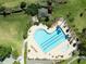 Aerial view of a heart-shaped community pool surrounded by lush greenery and inviting lounge chairs at 3071 Shoal Creek Village Dr, Lakeland, FL 33803