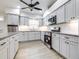 Modern kitchen featuring white cabinets, granite countertops, stainless steel appliances, and new flooring at 3080 Westmoreland Dr, Lakeland, FL 33810