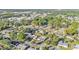 Aerial view showcasing neighborhood with lush trees, nearby city buildings and a clear blue sky at 3134 Hilltop S Ave, Lakeland, FL 33803