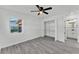 Bedroom featuring grey wood floors, closet, ceiling fan, and a view into the bathroom at 3134 Hilltop S Ave, Lakeland, FL 33803