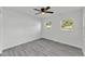 Bedroom featuring grey wood floors, ceiling fan, and two windows at 3134 Hilltop S Ave, Lakeland, FL 33803