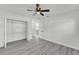 Bright bedroom showcasing gray vinyl floors, a closet with wire shelving, and an overhead ceiling fan at 3134 Hilltop S Ave, Lakeland, FL 33803