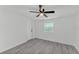 Bright bedroom featuring modern gray flooring, a ceiling fan, and a window, offering a comfortable living space at 3134 Hilltop S Ave, Lakeland, FL 33803