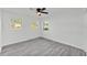 Bedroom featuring grey wood floors, ceiling fan, and three windows at 3134 Hilltop S Ave, Lakeland, FL 33803