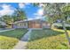 The front of the home is highlighted with wood accents, a metal roof, and a well-maintained lawn at 3134 Hilltop S Ave, Lakeland, FL 33803