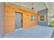 Inviting front porch with modern wood paneling, stylish light fixture and gray accents at 3134 Hilltop S Ave, Lakeland, FL 33803