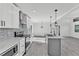 Modern kitchen with white cabinets, herringbone backsplash, stainless appliances and a center island at 3134 Hilltop S Ave, Lakeland, FL 33803