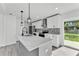 Bright kitchen featuring white cabinets, stainless appliances, a center island and sliding glass doors at 3134 Hilltop S Ave, Lakeland, FL 33803