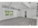 Bright living room featuring grey wood floors, clerestory windows, and an entry into another room at 3134 Hilltop S Ave, Lakeland, FL 33803