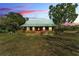 Charming single-story home featuring a green metal roof and spacious front yard with mature trees, offering classic curb appeal at 3530 Hamilton Rd, Lakeland, FL 33811