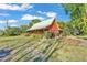 Charming red home with a metal roof, covered porch and lovely landscaping at 3530 Hamilton Rd, Lakeland, FL 33811