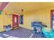 Covered porch features wood decking, seating, grill, and front door access at 3530 Hamilton Rd, Lakeland, FL 33811
