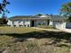 Charming single story home with a well-manicured lawn, decorative shutters, and an attached garage on a sunny day at 4215 Sabal Palm Dr, Mulberry, FL 33860