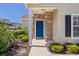 Home entryway featuring a blue door, stone accents, and well-maintained landscaping at 4227 Hartridge Ln, Lakeland, FL 33813